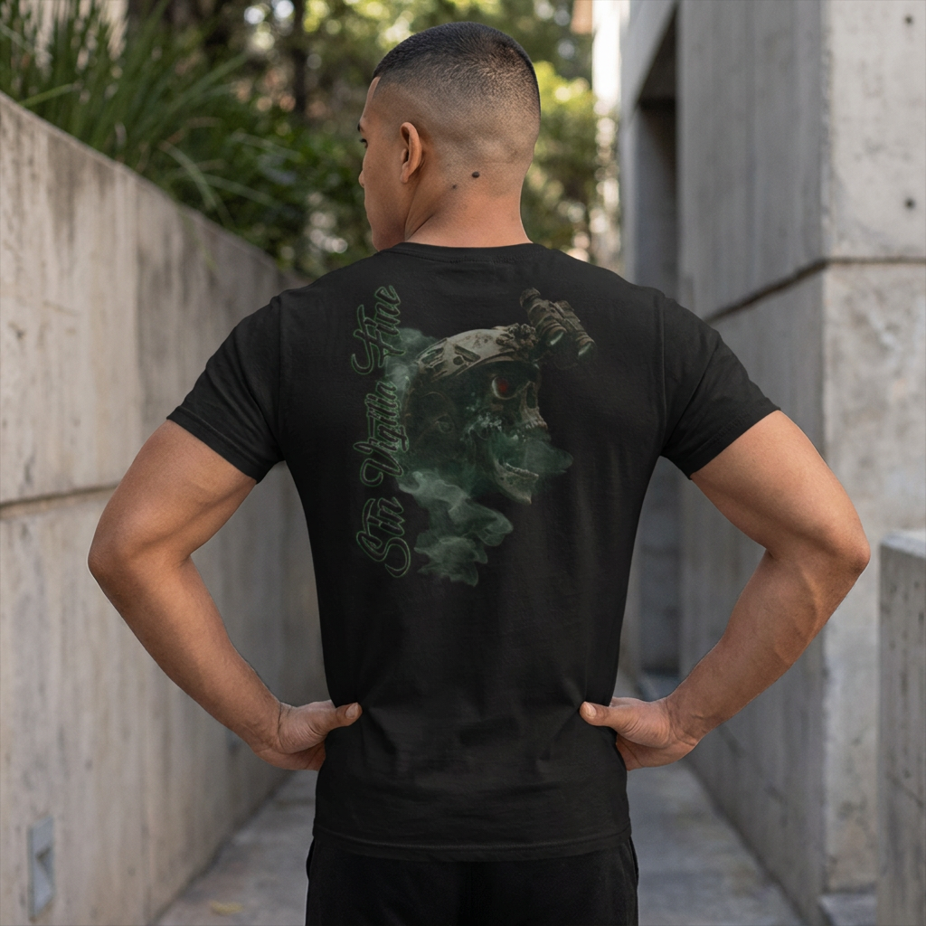 A man viewed from behind wearing a black t-shirt with a large green and gray graphic print on the back, standing in an outdoor concrete walkway.